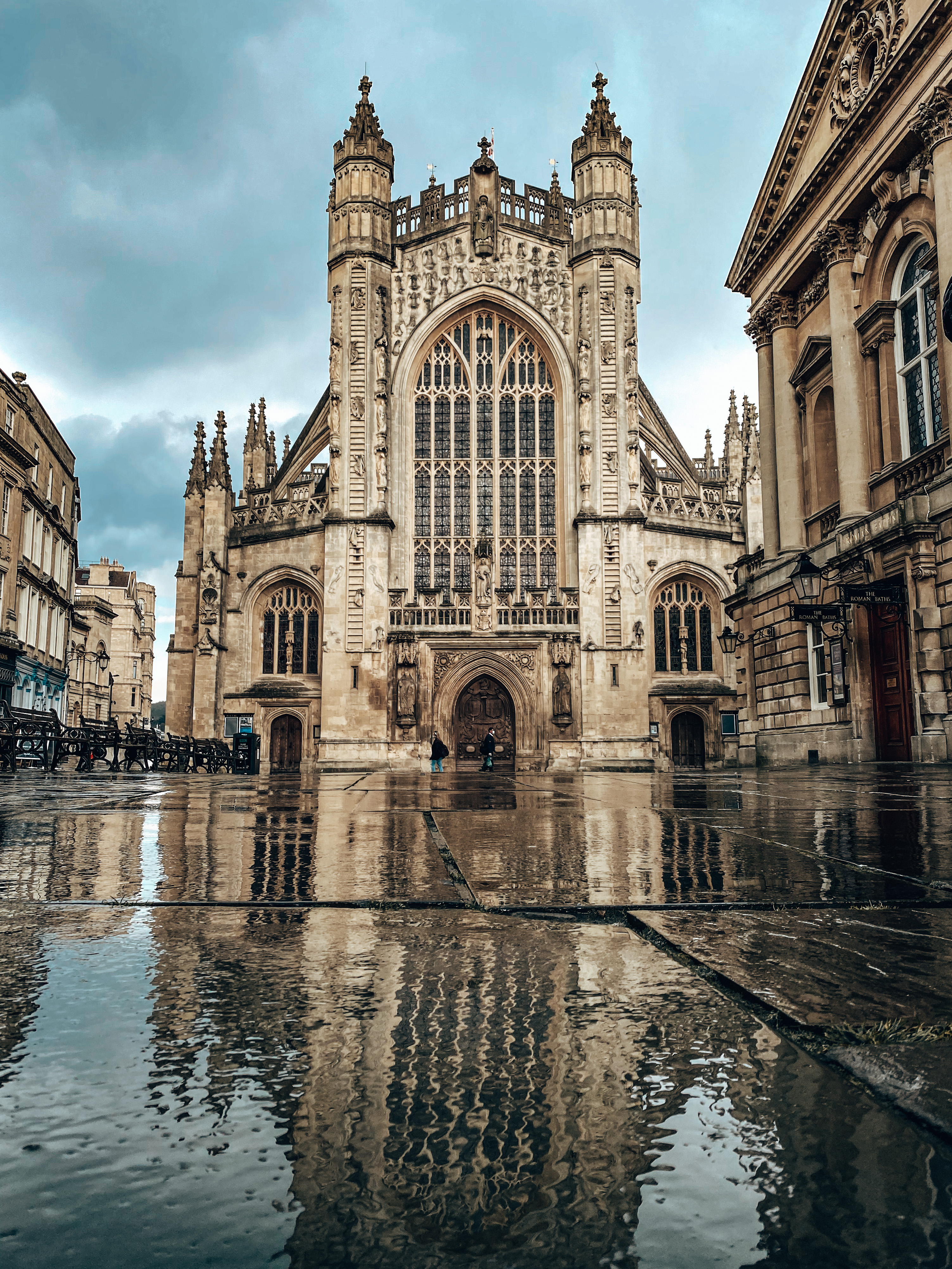 A church in Bath, England reflected in the rain on the ground below.